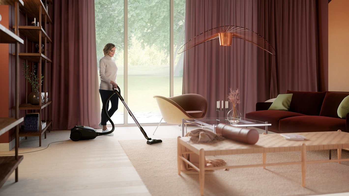 En kvinne støvsuger i en stue.